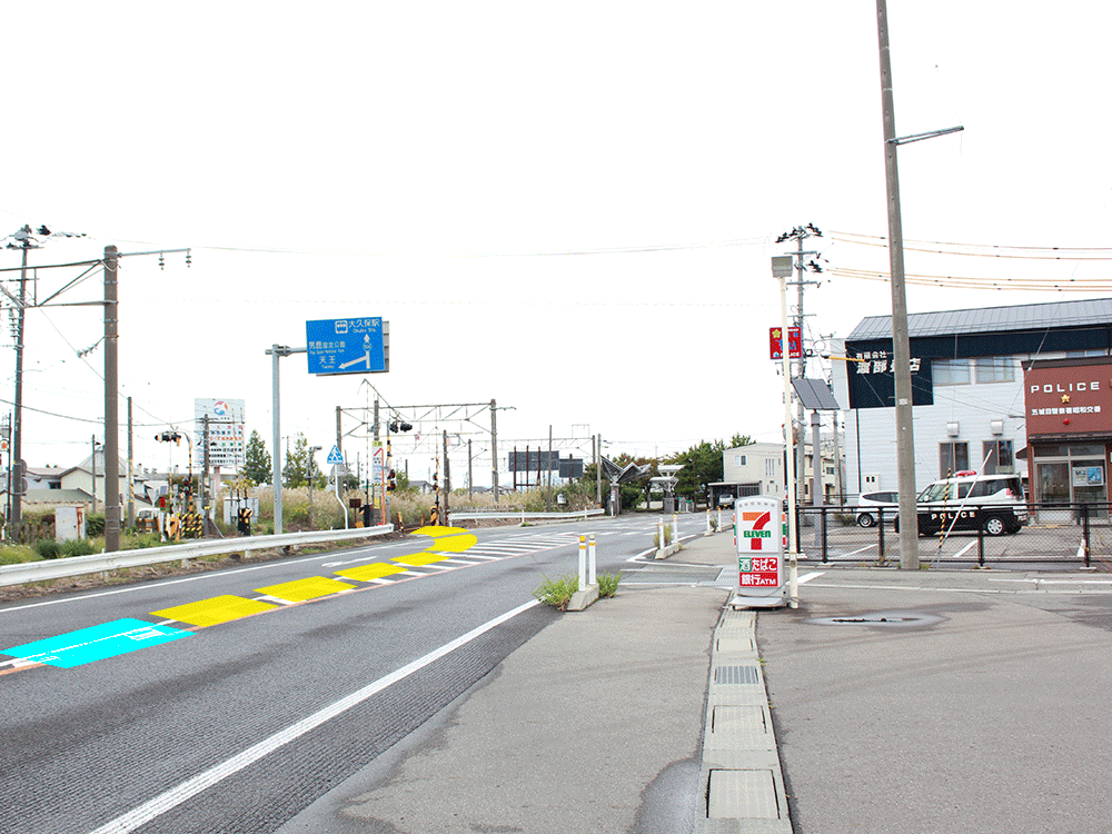 写真:秋田方面からJR奥羽本線大久保方向へむかい、コンビニと交番を右手に踏切を渡り、右折します。